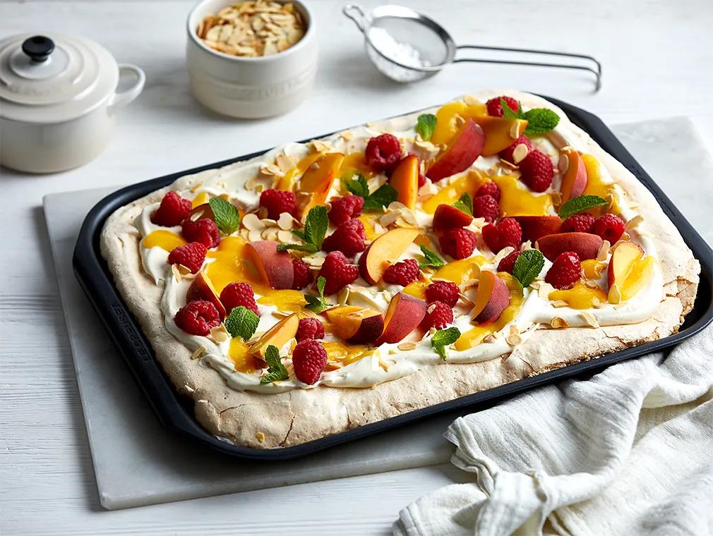 Pavlova aux pêches, framboises et amandes